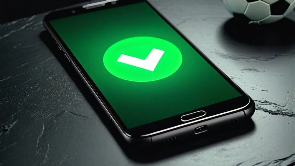 Celular con una marca de verificación verde en pantalla junto a un balón de futbol